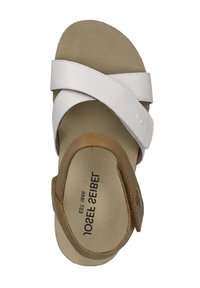 Bruine en witte sandalen met kruisbanden, een gevoerde beige binnenzool, gladde leren banden en een platte zool. Merknaam zichtbaar.