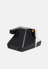 Un appareil photo instantané avec un boîtier géométrique noir, des accents blancs, un bouton d'alimentation jaune et un viseur, présentant un design distinctif et angulaire.