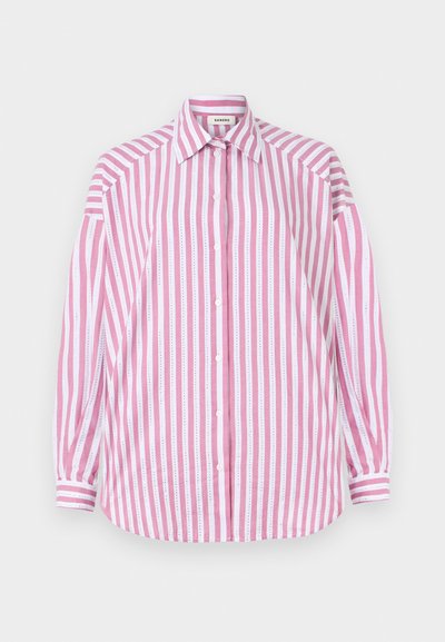 Stribet skjorte med pink og hvide lodrette striber, lange ærmer, klassisk krave, knaplukning foran og en buet kant. Materialet er bomuld.
