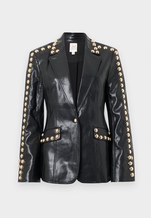 Zwarte leren blazer met gouden studs langs de schouders en zakken, voorzien van een puntige kraag en een getailleerde pasvorm. Soepele textuur.