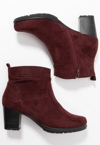 Bordowe zamszowe botki za kostkę z blokowym obcasem, bocznym zamkiem błyskawicznym i kontrastowym przeszyciem. Okrągły czubek i elastyczna gumowa podeszwa.