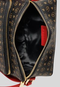 Borsa nera a fantasia con zip dorate, interno e dettagli rossi. Presenta un'esterno in morbida ecopelle e un interno ampio e non strutturato.