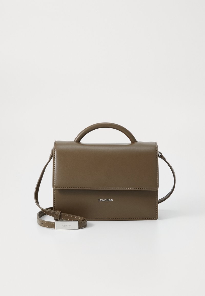 Sac à main rectangulaire en cuir vert olive avec poignée supérieure et bandoulière réglable, doté d’une fermeture à rabat et du logo Calvin Klein sur le devant.