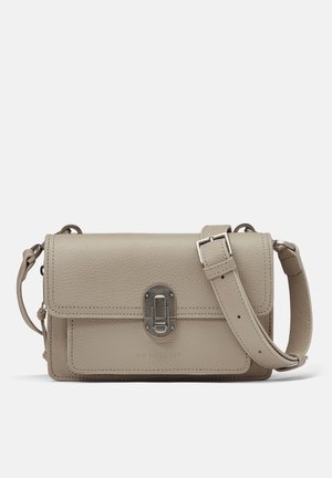 Kleine beige leren crossbodytas met voorflap, zilverkleurige gespsluiting en verstelbare schouderband op een effen achtergrond.