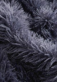 Tissu doux et duveteux gris foncé et noir avec de longues fibres fines créant une surface texturée et pelucheuse.