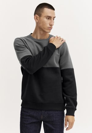 Grijs en zwart kleurblok sweatshirt met een ronde halslijn en geribbelde manchetten. Gladde textuur en ontspannen pasvorm. Opvallend accent op de schouder.