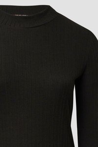 Schwarzes Langarmoberteil mit hohem Ausschnitt und strukturiertem Rippmuster. Der Stoff ist glatt mit vertikalen Linien, die eine figurbetonte Silhouette formen.