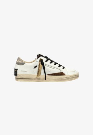 Sneakers in pelle bianca con lacci neri, dettagli in suede marrone e suola texture. Presentano un marchio e un'etichetta decorativa sul lato.