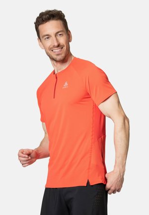 Bright orange athletic shirt with short sleeves, a quarter zip at the collar, and a slim fit. Features side vents and a reflective logo.
