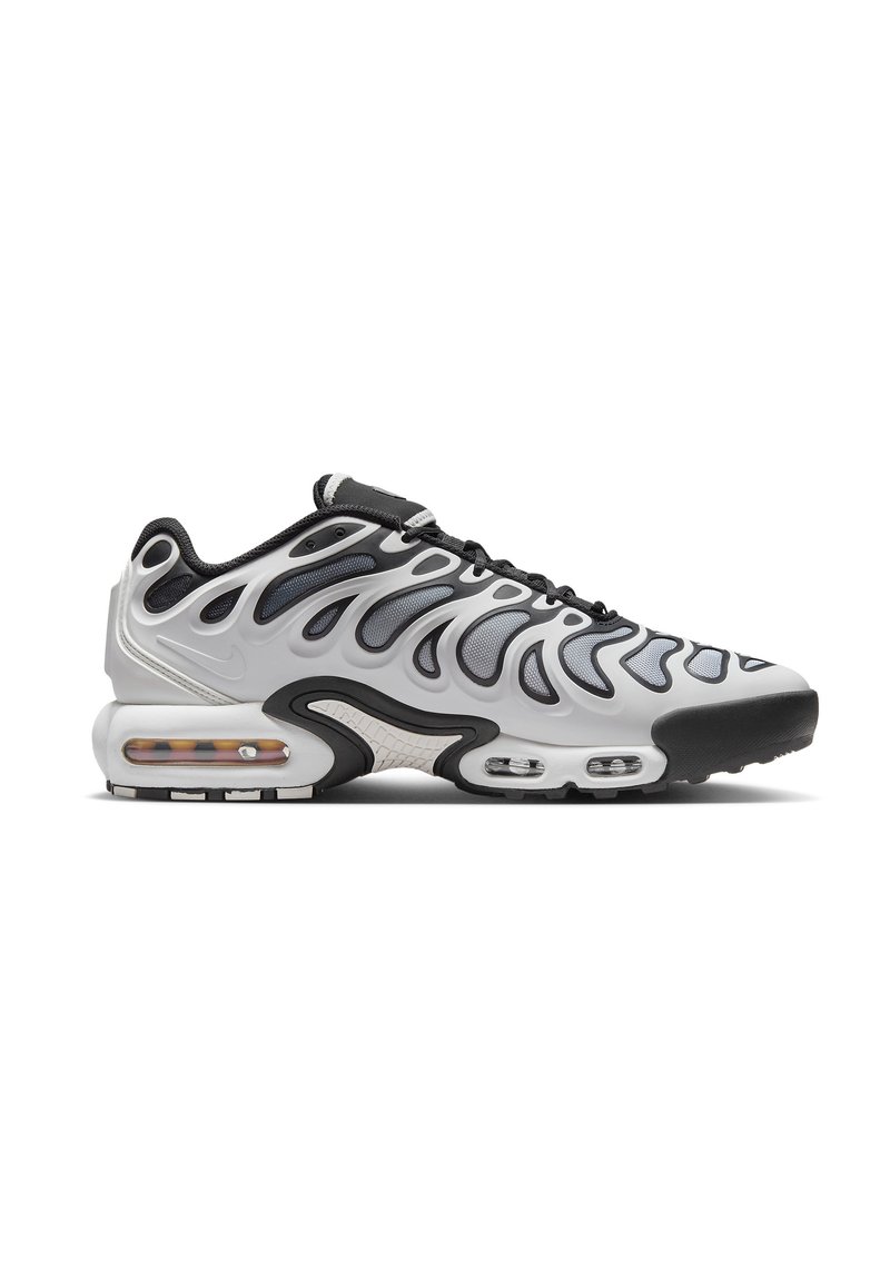 Baskets Nike noir et blanc avec un design supérieur ondulé, texture en maille, amorti à air visible et semelle extérieure en caoutchouc.