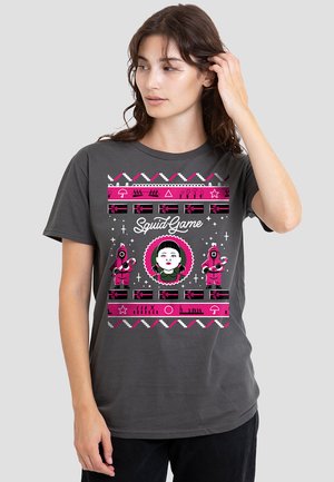 Dark gray t-shirt featuring a colorful graphic of characters and symbols from "Squid Game," with pink and white accents and a round central image.
