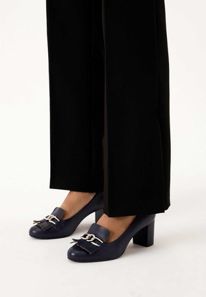 Navy leather high-heeled shoes with a rounded toe, featuring a silver-toned hardware accent and decorative fringe detail.