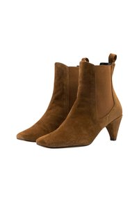 Botas de tobillo de ante marrón con punta afilada, paneles laterales elásticos y un tacón cónico de 5 cm. Cuenta con tiradores en la parte superior para ponerlas fácilmente.