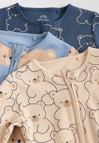 Tre tutine per neonato in morbido tessuto, con motivi di orsetti nei colori blu, beige e crema, impilate su uno sfondo chiaro.