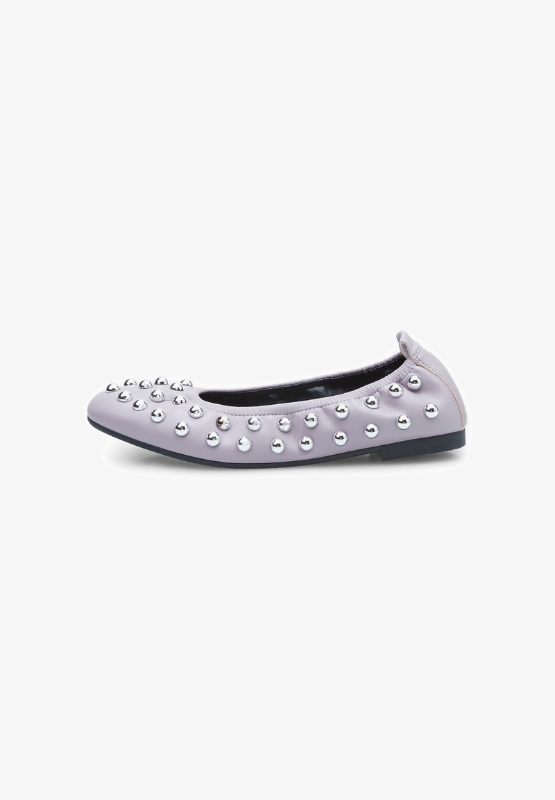 Scarpa piatta in lavanda chiaro con punta arrotondata, adornata con borchie metalliche sulla tomaia, texture in pelle liscia e suola nera.