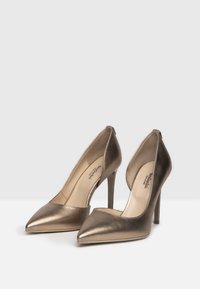 Talons hauts en bronze métallisé avec une pointe et un design découpé. Texture lisse avec un talon aiguille, dotés d'une semelle intérieure rembourrée.