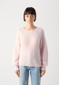 Pink knitted sweater with a soft, fluffy texture, round neckline, and balloon sleeves. Elbow seams feature a subtle decorative detail.
