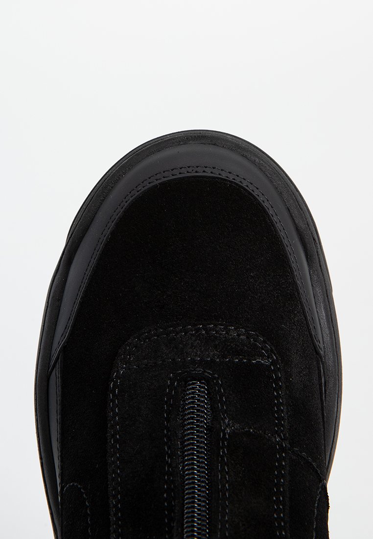 Schwarze Wildleder-Sneaker mit einer glatten Lederkappe, elastischem Seiteneinsatz und tonalem Nähen, ausgestattet mit einer abgerundeten Form und einem Slip-On-Design.