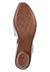 Sandalia de cuero perforado blanco con una base de goma texturizada marrón. Presenta una puntera lisa y puntiaguda, y acentos laterales flexibles. Talla 37.