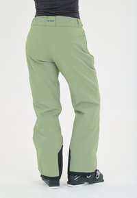 Lichtgroene skibroeken met een relaxte pasvorm, voorzien van een brede tailleband en zwarte accenten bij de mouwen, ontworpen voor wintersport.