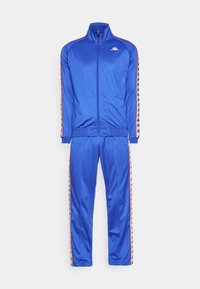 Blauwe trainingspak met een ritssluiting jas en bijpassende broek. Gemaakt van glad materiaal met contrasterende zijkanten en logo-accenten.