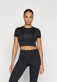 Black, cropped athletic t-shirt with short sleeves, smooth texture, and a round neckline, paired with black high-waisted leggings.