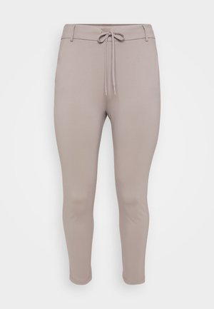 Light beige, fitted jogger pants with a drawstring waist and tapered legs, displayed against a plain background.