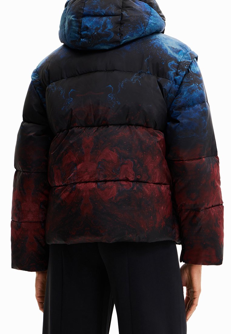 Pufferjack in zwart, blauw en rood abstract patroon. Beschikt over een capuchon en een gestikt ontwerp, met een zachte, gladde textuur.