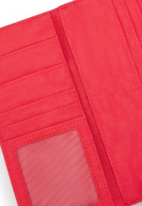 Red fabric wallet interior featuring multiple card slots, a transparent ID window, and a textured finish. Stitched edges detail.