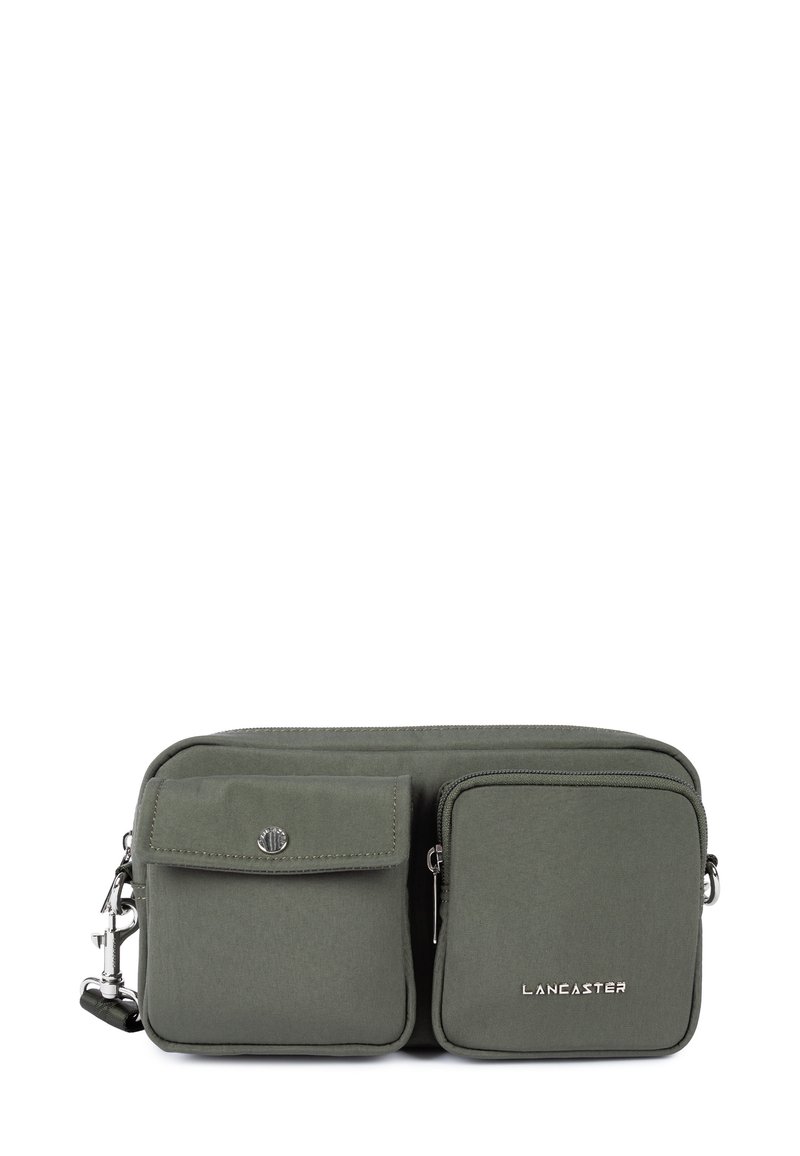Borsa a tracolla verde in tessuto con due tasche frontali, hardware argentato e chiusura con zip. Presenta un logo impresso sul davanti.