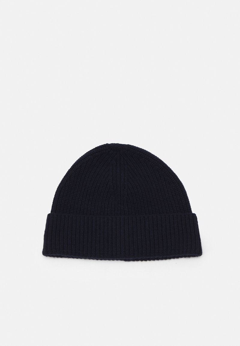 Pīta beanie tumši zila krāsā ar teksturētu ribu rakstu un plašu apmali. Mīksts audums ar noapaļotu augšu.