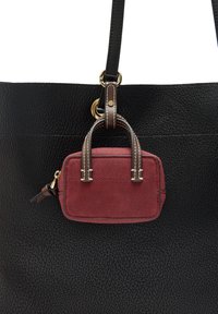 Czarna skórzana torba tote o teksturowanej powierzchni z małą burgundową zamszową torbą przymocowaną do niej, podkreśloną brązowymi skórzanymi uchwytami i detalami w szwie.