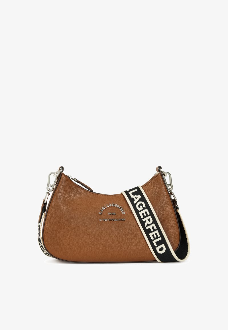 Borsa a spalla in pelle marrone con forma curva, dotata di un dettaglio con logo argento e una tracolla a strisce nere con testo.