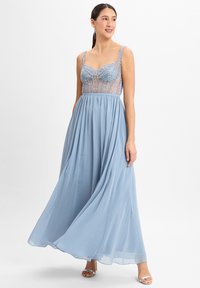 Himmelblaues Abendkleid mit einem bestickten Oberteil und durchsichtigen Details, fließendem Rock und zarten Trägern. Verfügt über eine glatte, weiche Textur.