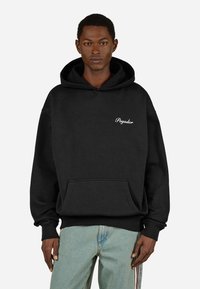 Felpa nera con cappuccio realizzata in misto cotone, con tasca frontale e testo "Pegador" bianco sul petto. Texture morbida con vestibilità comoda.