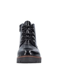 Chaussures noires en cuir verni à bout rond, avec des œillets en métal, des lacets noirs et une semelle épaisse noire. Fini lisse et brillant.