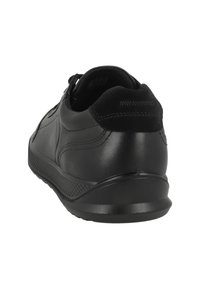 Sort lædersneaker med tekstureret sål, synlige syninger og polstret krave, vist fra bagfra i skrå vinkel.