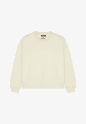 Beżowa bluza z okrągłym dekoltem o luźnym kroju, z prążkowanymi mankietami i dolnym wykończeniem. Połączona z jasnoniebieskimi, wysokim stanem jeansami. Prosty design, swobodny wygląd.