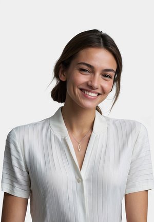 Camicia bianca a maniche corte con righe verticali e colletto. Collana con pendente argento a forma di goccia.
