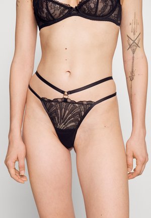 Conjunto de lingerie de renda preta com um soutien com aros e detalhes intrincados em renda, combinado com um fio dental com alças e um padrão floral.