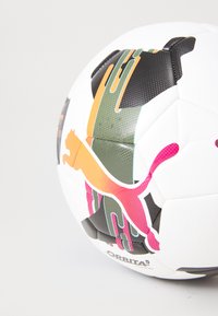 Hvid fodbold med en tekstureret overflade, der har multikulturelle grafikker, herunder et logo, dristige mønstre og kontrasterende sorte accenter.