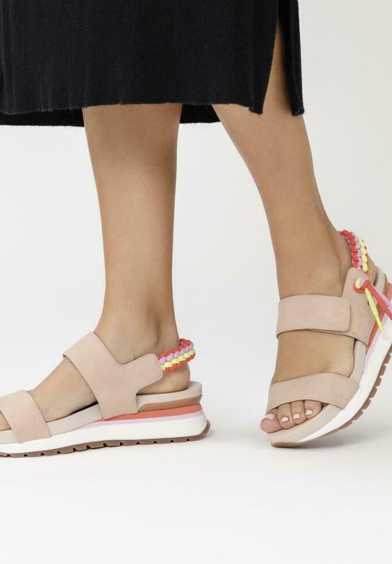 Sandalias de color rosa claro con dos tiras anchas, parte superior texturizada y acentos de patrón multicolor en el talón. Suela de goma blanca gruesa.
