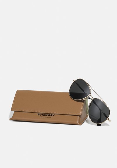 Occhiali da sole aviator Burberry con lenti nere accanto a un astuccio in pelle beige, con un branding discreto in stampa nera.