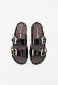Sandales noires à glissière avec deux brides texturées et brillantes, dotées de boucles ajustables en métal doré. Semelle intérieure grise douce avec des détails de la marque. Taille 37.