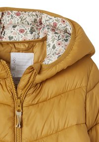 Gul pufferjakke med lynlåslukning og hætte. Foret med et blomsterprint i pink og grøn, tekstureret stof med quiltede detaljer.