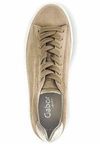 Beige Wildleder-Sneaker mit runder Zehenpartie, Schnürung, gepolstertem Kragen und metallischen Akzent an der Ferse. Weiße Gummisohle, minimalistisches Design.