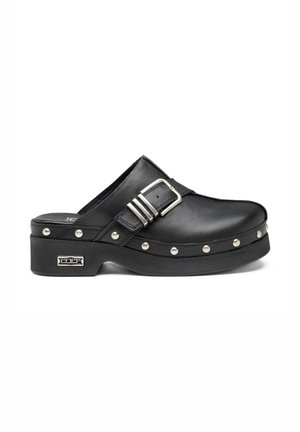 Zoccolo slip-on in pelle nera con fibbia argentata, borchie metalliche lungo la suola e logo metallico del marchio sul tallone.
