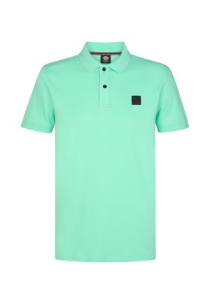 Hellgrünes Poloshirt aus Baumwolle, mit einer Dreiknopfleiste und einem schwarzen quadratischen Logo-Patch auf der linken Brust. Kurzärmelig.