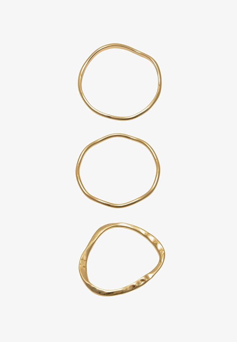 Trei brățări subțiri din aur, cu forme neregulate, aranjate vertical pe un fundal alb.