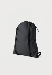 Μαύρο σακίδιο με κορδόνι κατασκευασμένο από λείο, αδιάβροχο υλικό, με στρογγυλεμένη σιλουέτα και μία μόνο φερμουάρ κλείσιμο στην κορυφή.